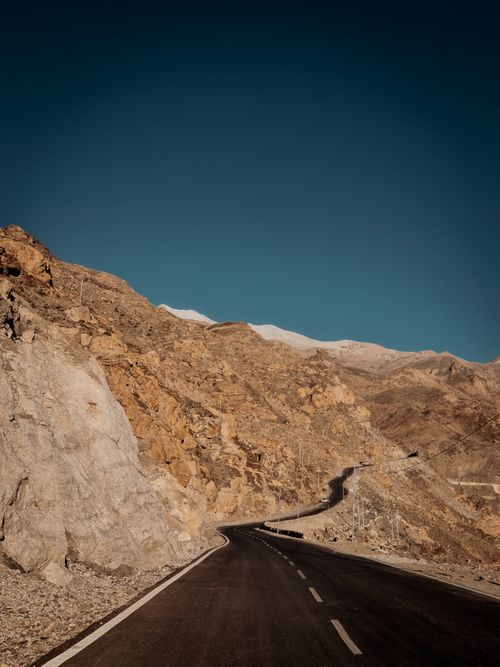 Free Road through barren mountain landscape in Himachal Pradesh, India, under clear sky. Stock Photo