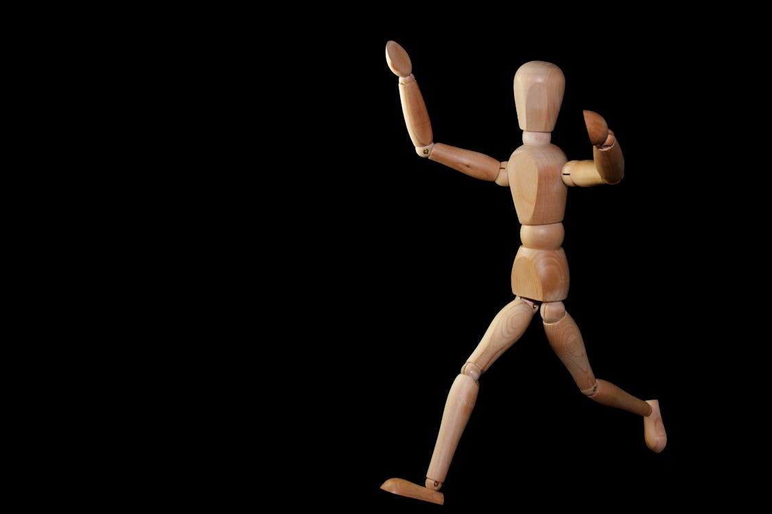 Free Timelapse Photography of Brown Wooden Puppet Running on a Black Screen Stock Photo
