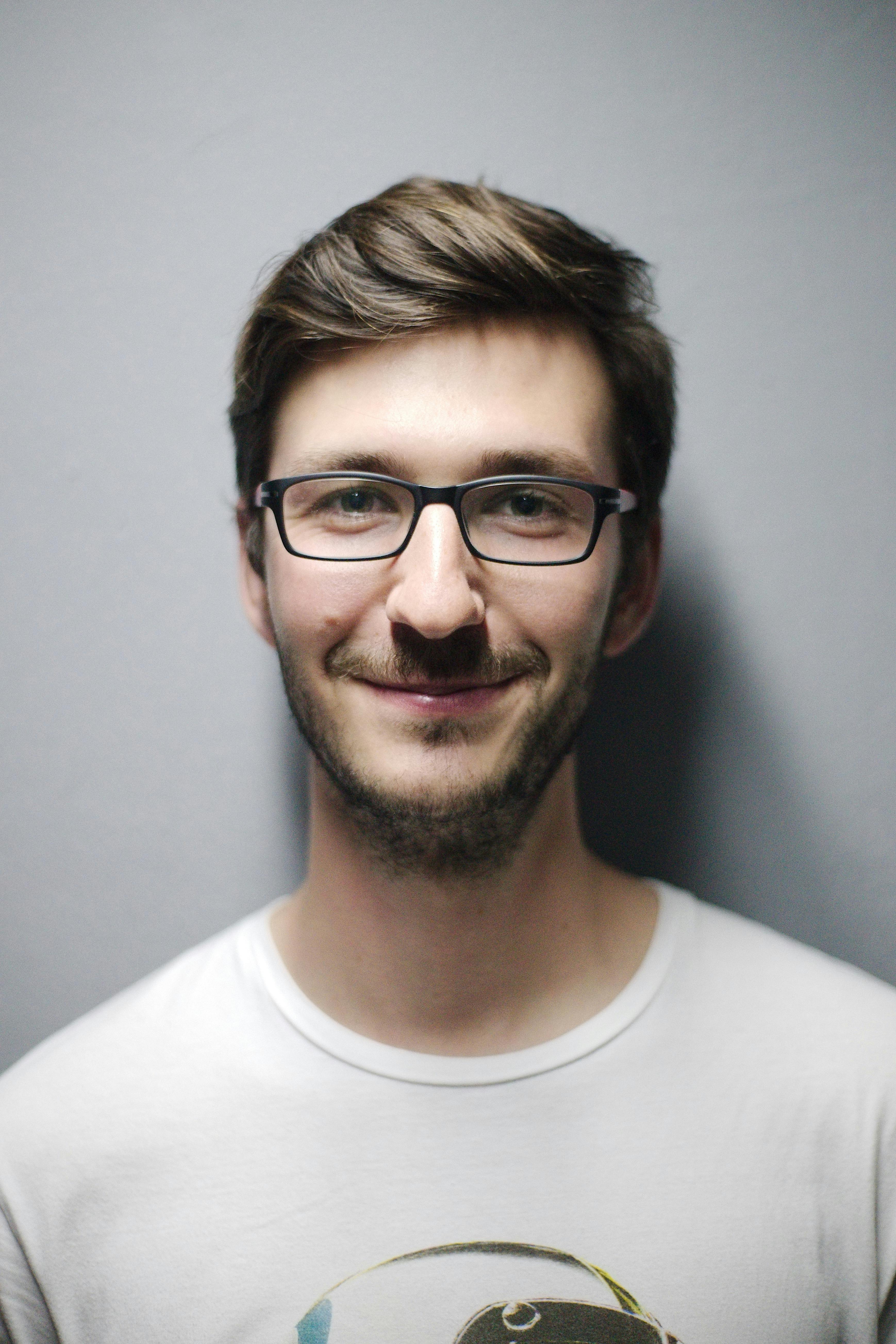 man smiling behind wall