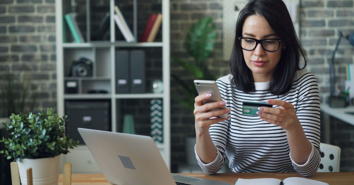 Hispanic woman comparing car insurance options on laptop and smartphone at Texas home
