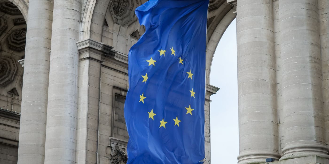 European Union flag fluttering beneath the Cinquantenaire Arch in Brussels, Belgium.