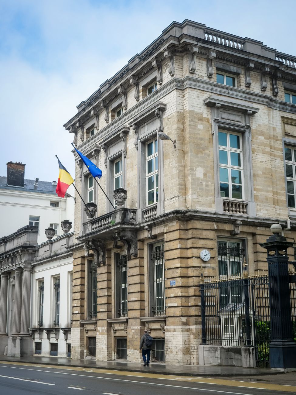 Overheidsgebouw in de stad Brussel, met architectuur die de Belgische en Europese vlaggen toont.