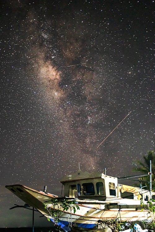 A boat under the stars with a milky way in the background