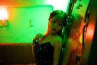 一位时尚女性在充满活力的绿色灯光下倒映出迷人的身影