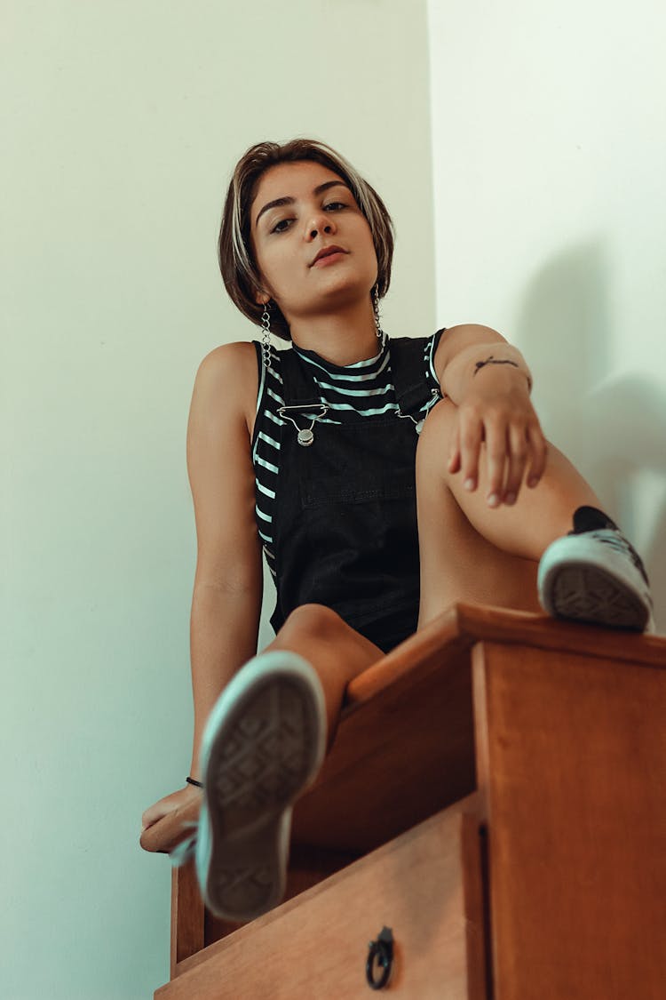 Woman Sitting On Brown Wooden Dresser