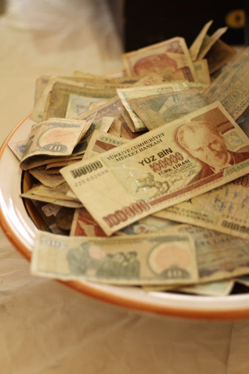 A bowl full of money sitting on top of a table