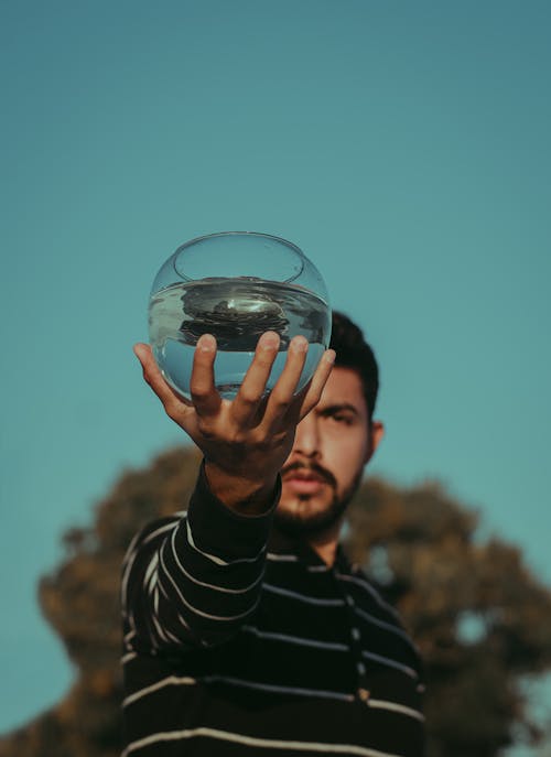 Photo of Man Holding Fish Bowl