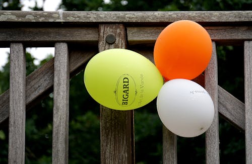 Gelber Orange Und Weißer Ballon Neben Grauem Holzzaun