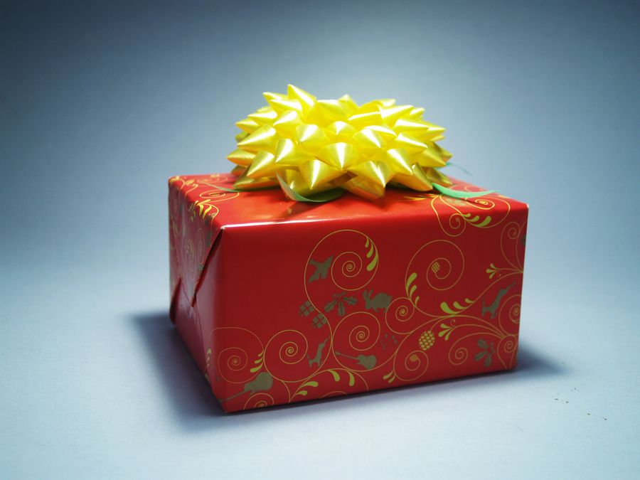 Inslagen julklapp i rött papper med rosett