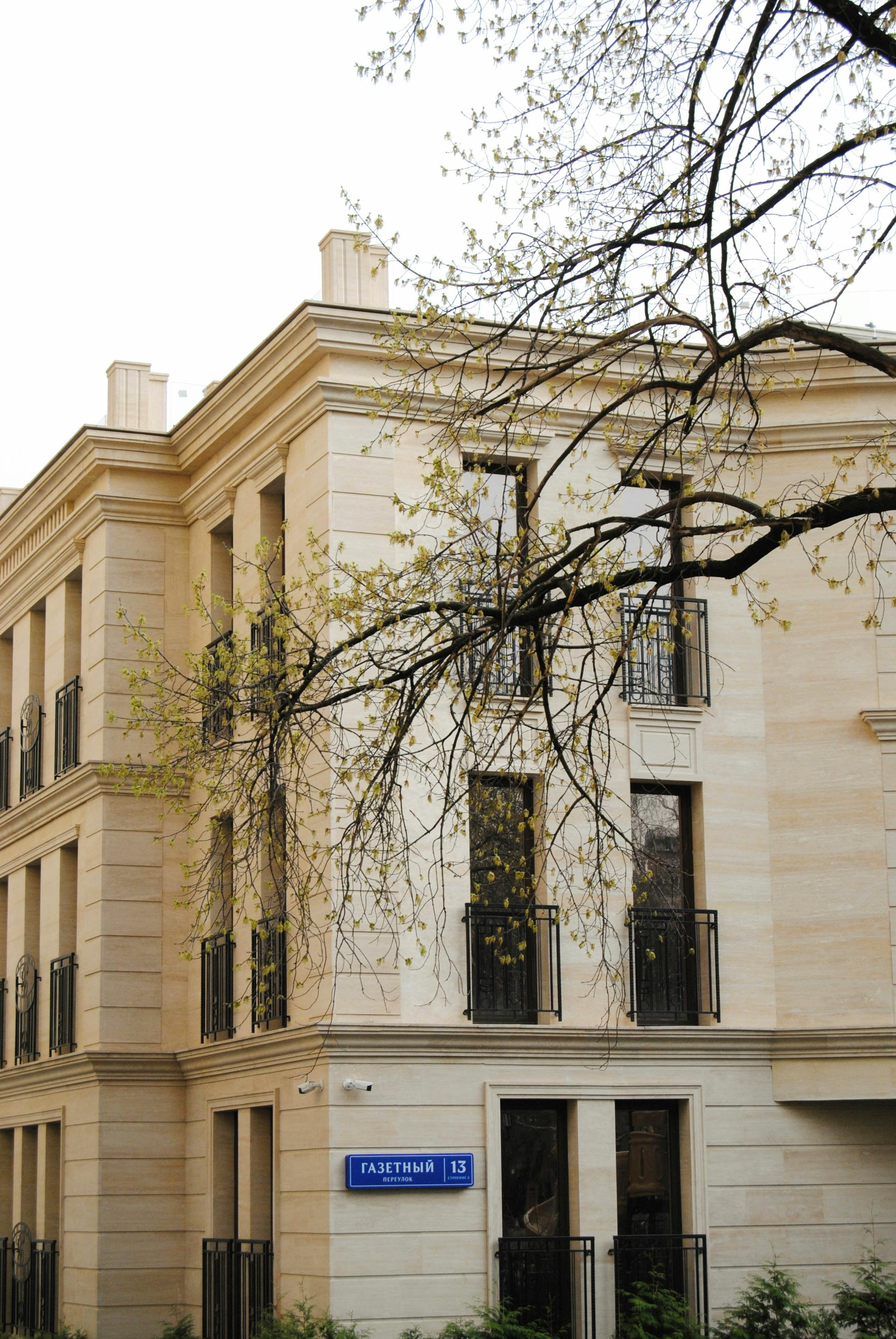 Charming building facade in Moscow with branches overhead, captured on a clear day.