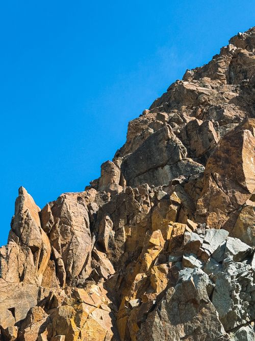 Free Dramatic rocky cliff under a clear blue sky in El Chaltén, Argentina's Santa Cruz province. Stock Photo
