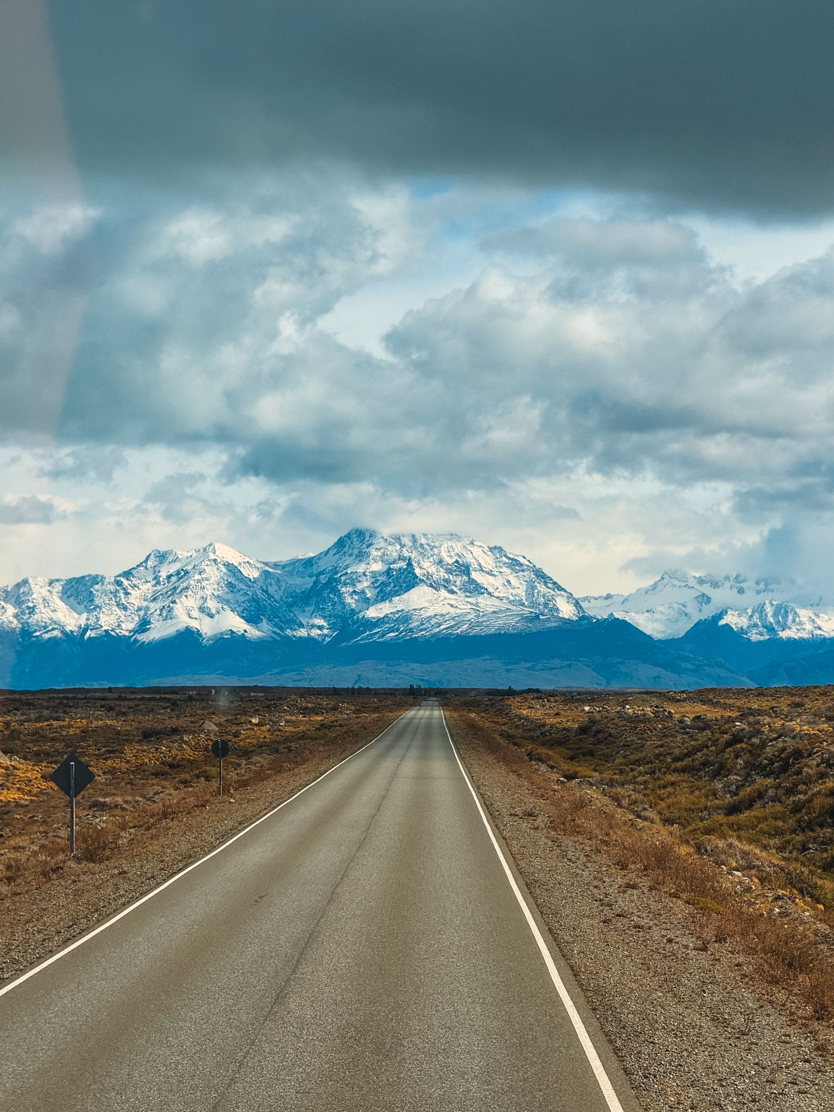 A picturesque highway stretches towards the snow-capped mountains of El Chaltén, Argentina.