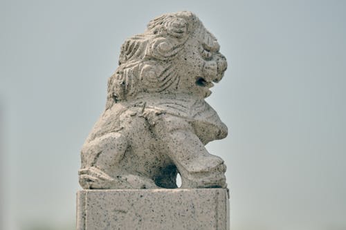 A stone lion statue on top of a building