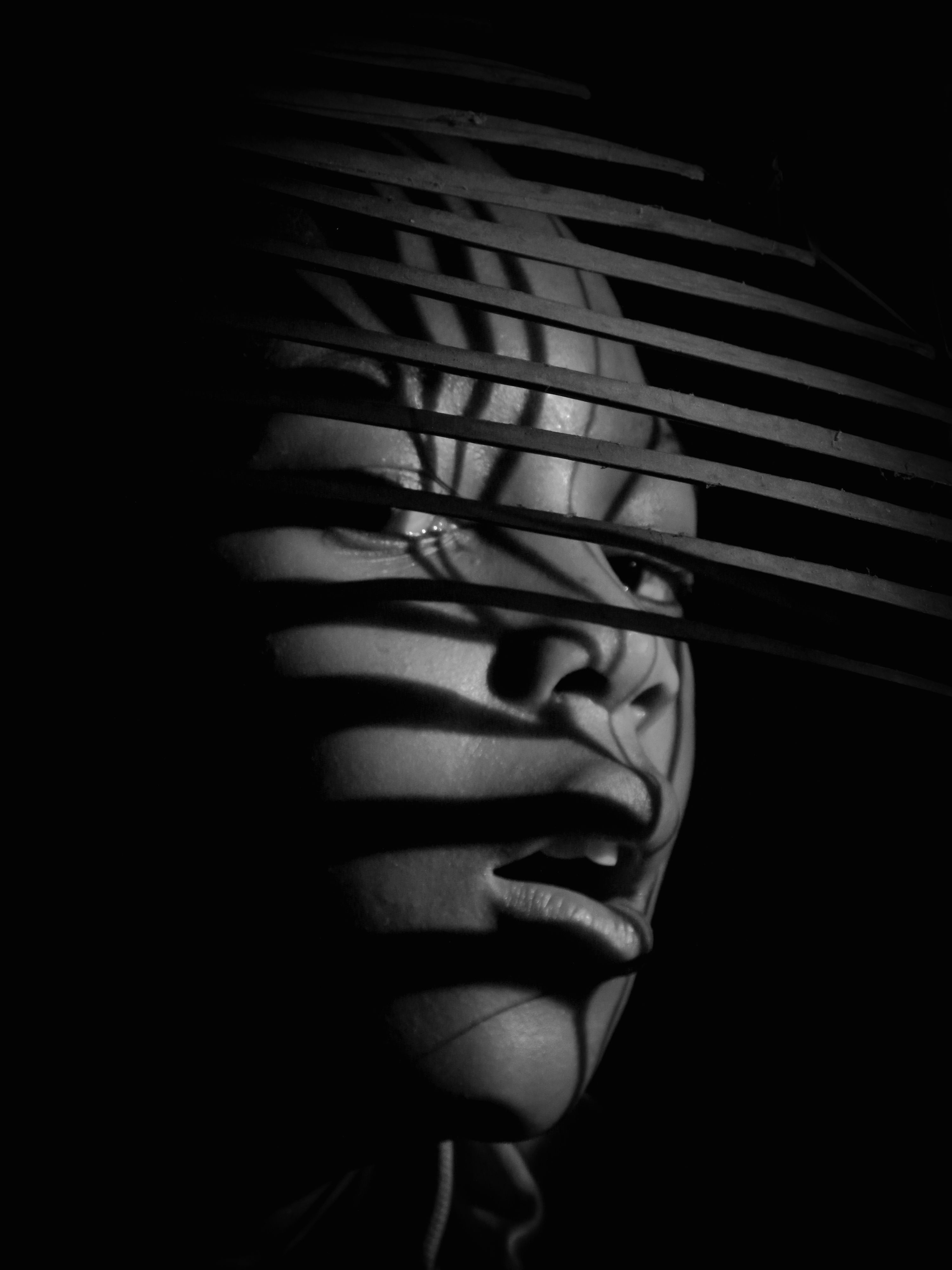 Artistic black and white portrait featuring striking shadow patterns in Nigeria.