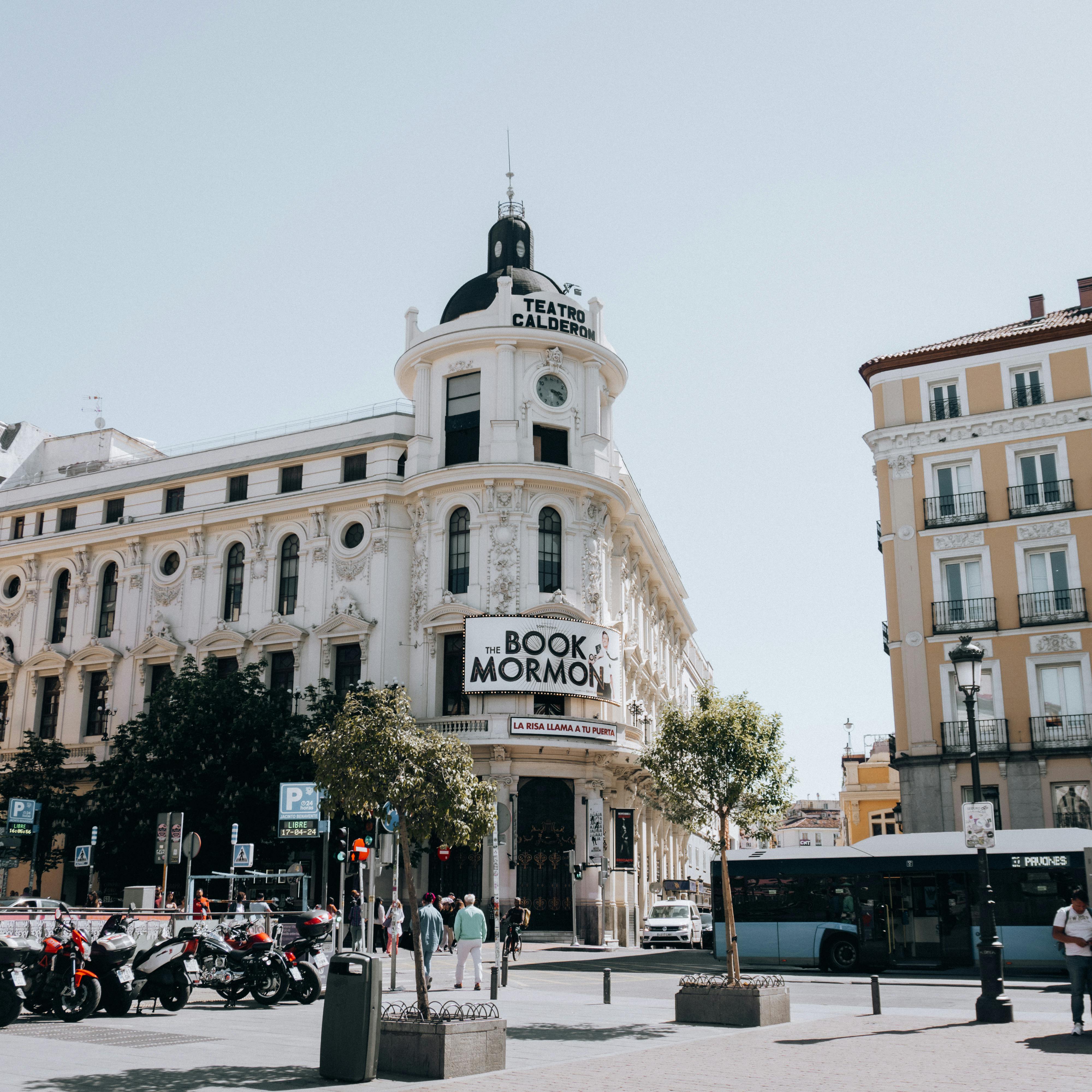 Free View of Teatro Calderón in Madrid with pedestrians and traffic on a sunny day. Stock Photo