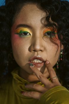 Colorful makeup close-up portrait of a woman with vibrant eye shadows and artistic expression.