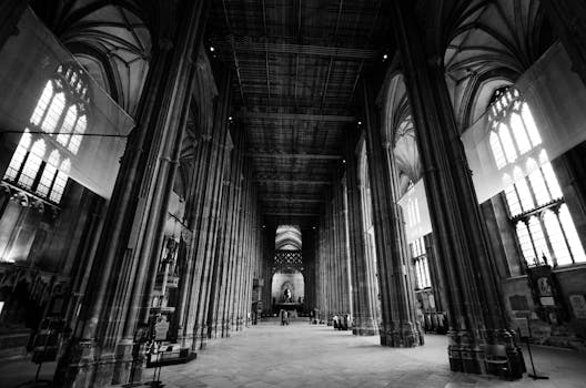 Explore the grandeur of a Gothic cathedral's interior, featuring towering columns and intricate details in monochrome.