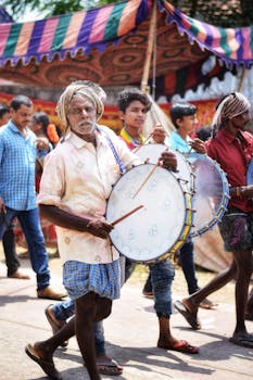 Colorful Indian festival parade featuring traditional drummers and vibrant cultural celebration on the street.