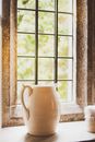White Ceramic Pitcher next to Window