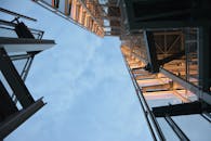 白天，低角度镜头下的现代钢结构直指天空