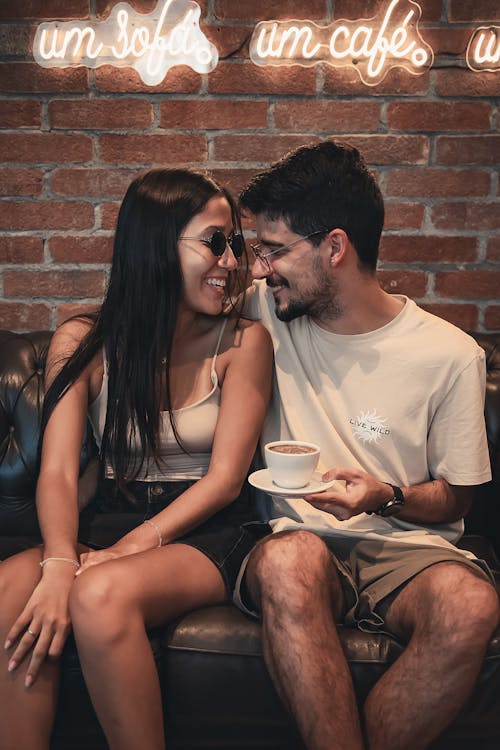 Couple sitting on couch with coffee and smiling