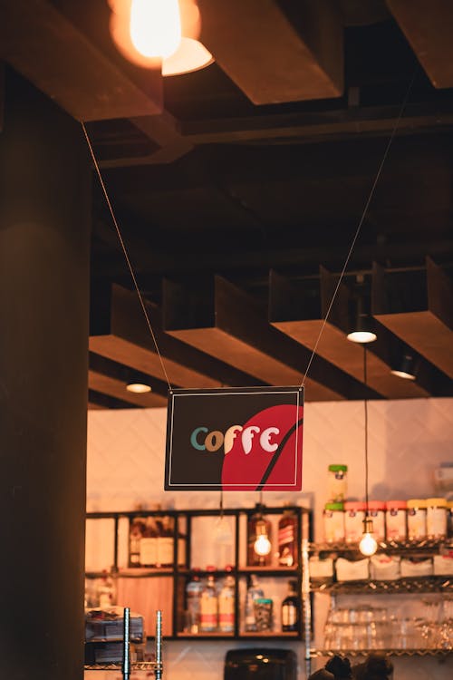 A sign hanging from the ceiling of a coffee shop