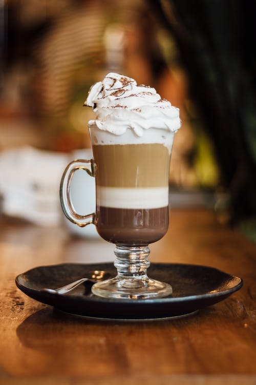 A glass of coffee with whipped cream on top