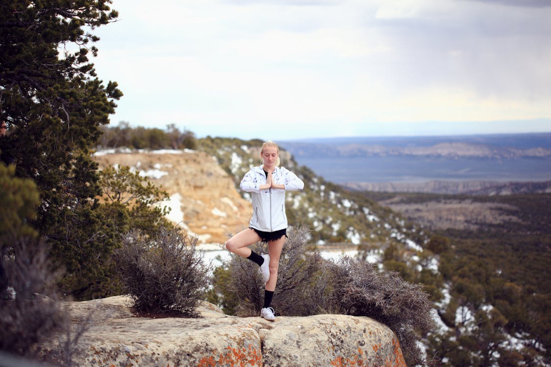 Woman doing yoga on a cliff