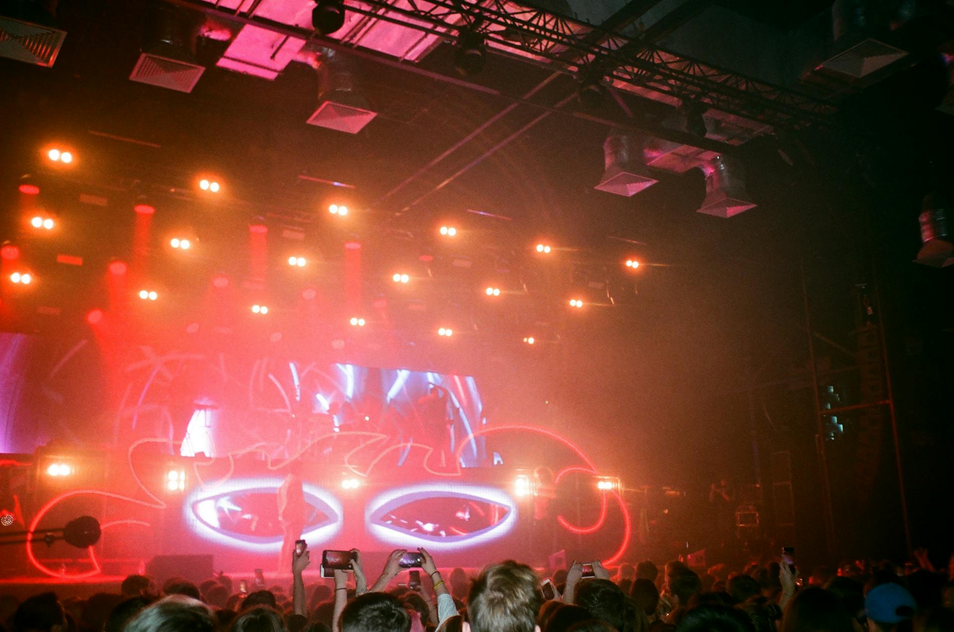 A lively concert scene with vibrant lights, crowd, and musicians on stage.