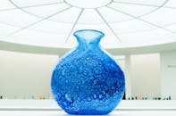 在现代博物馆明亮的灯光下，展示着一个令人惊叹的蓝色玻璃花瓶