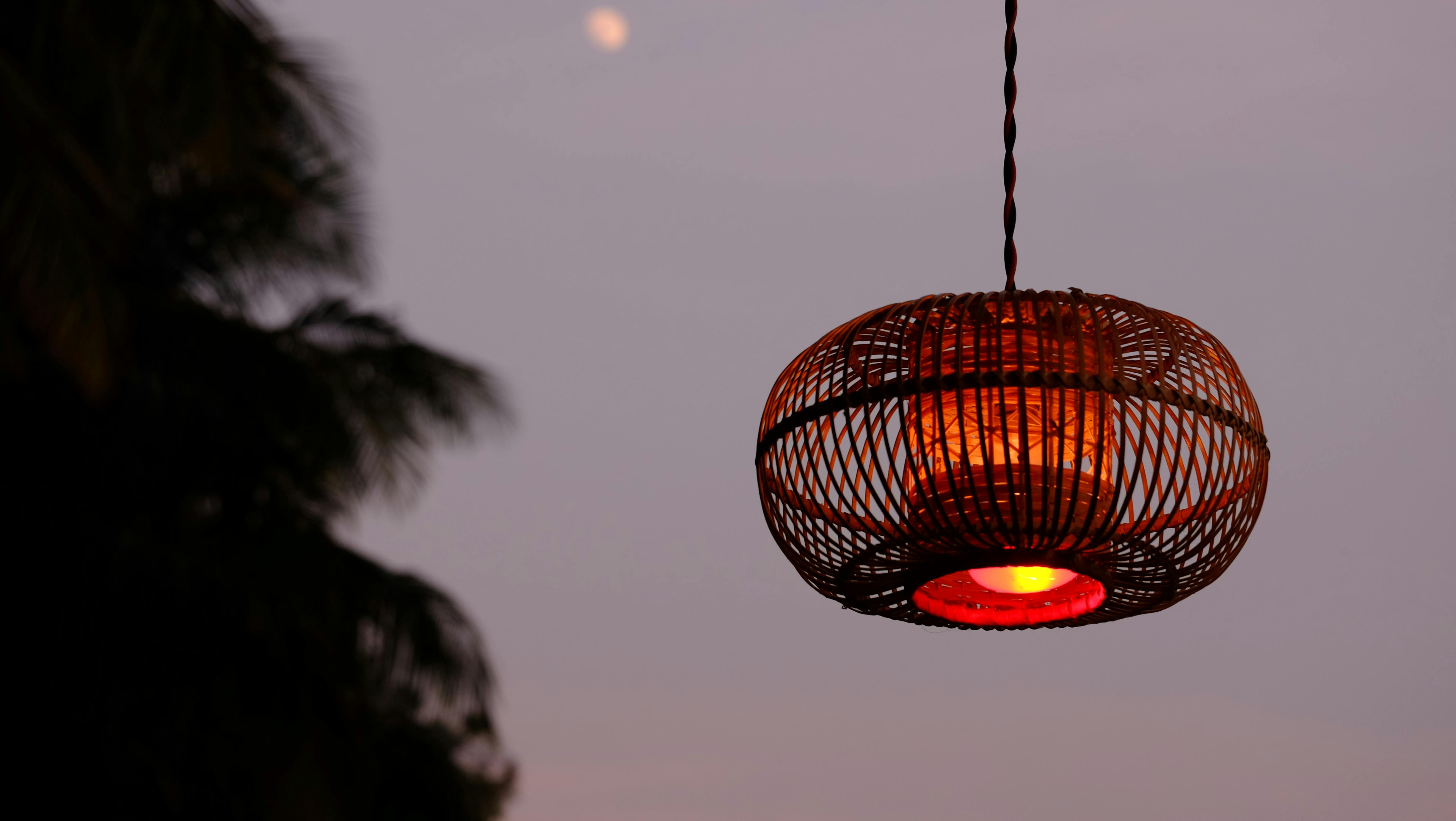 黄昏时分，一盏编织灯笼发出温暖的光芒，映衬着宁静的夜空