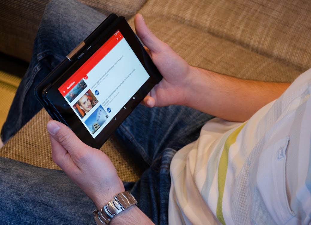 Free Person Holding Tablet Computer Showing Videos Stock Photo