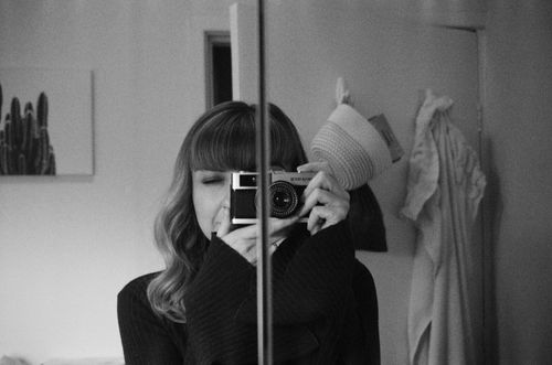 Free Monochrome image of a woman photographing herself in a mirror, capturing artistic reflection. Stock Photo
