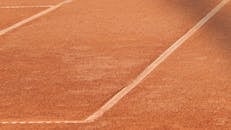 红土网球场的特写，清晰地展现了白线的细节图案