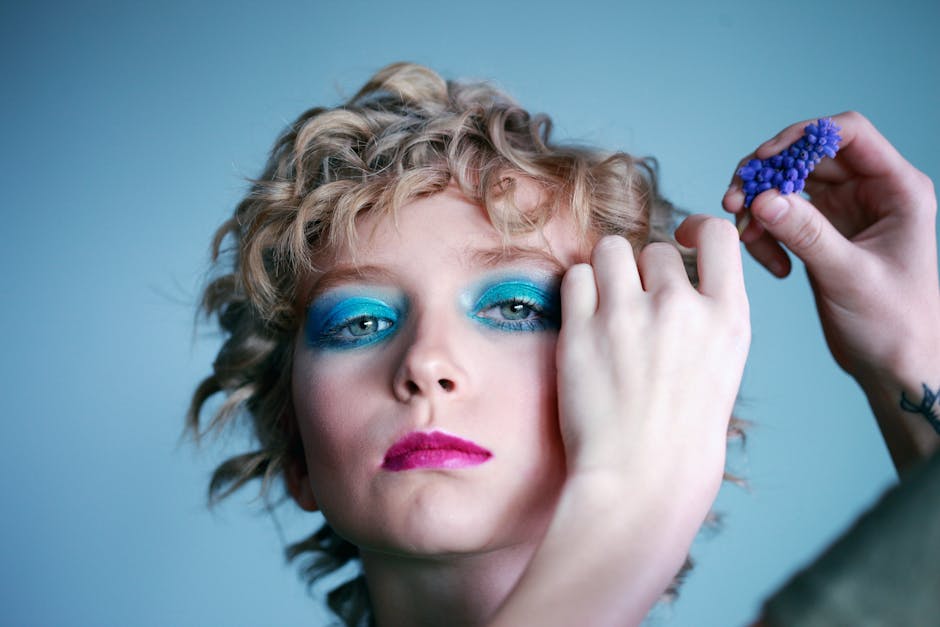 Close-up portrait highlighting vibrant makeup and hairstyle on a young woman.