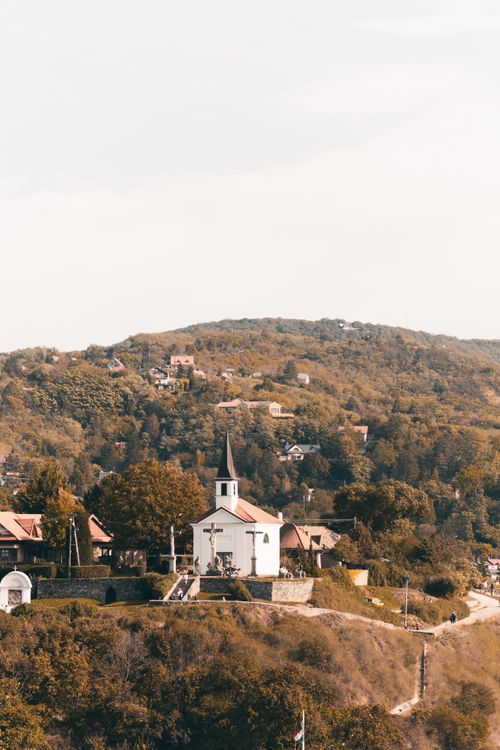 Free Charming church nestled on a hill in Esztergom, Hungary during autumn. Capturing serene rural beauty and tranquility. Stock Photo