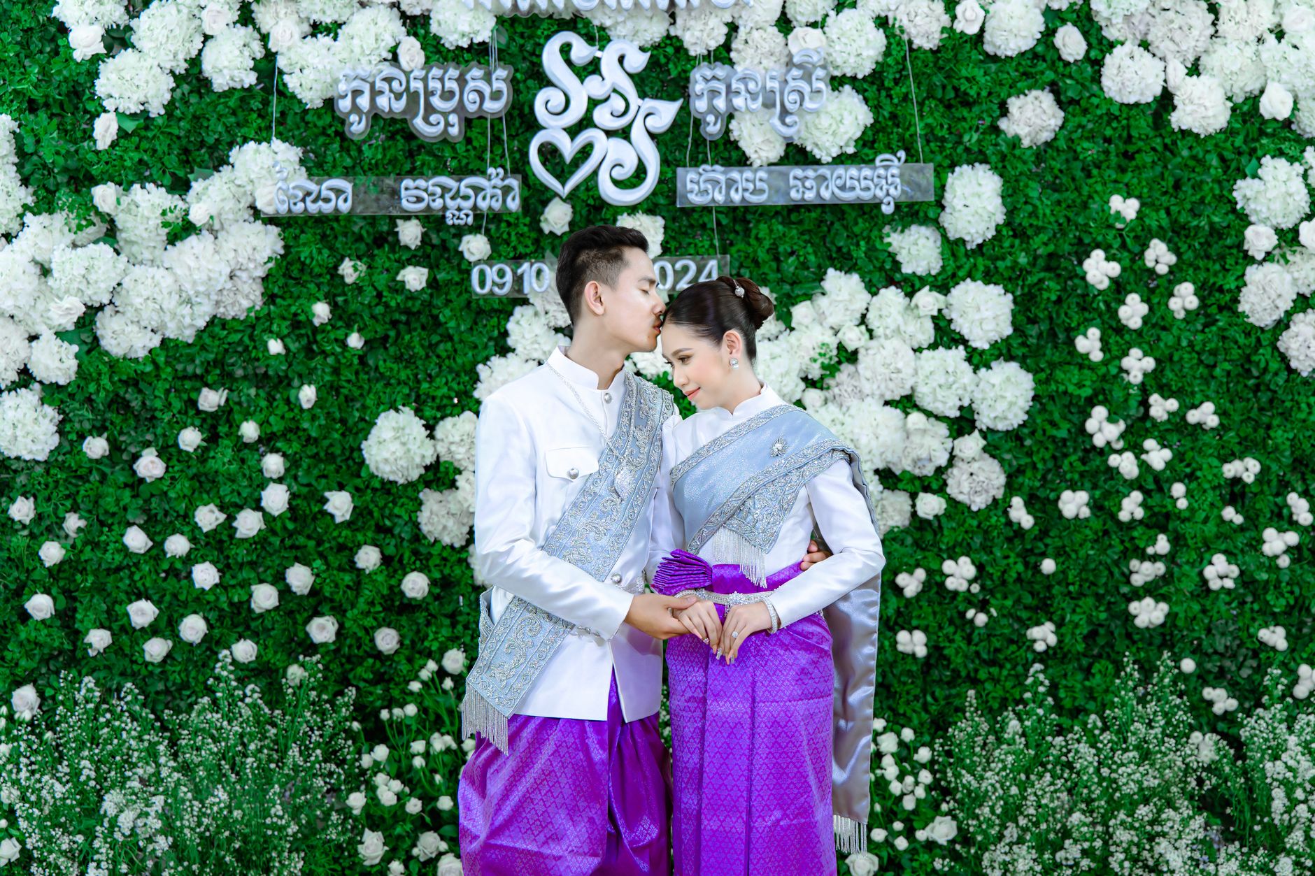 Captured moment of a couple in traditional Cambodian wedding attire, embraced in love.