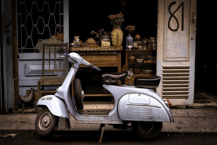 White And Black Motor Scooter Parked Near Building