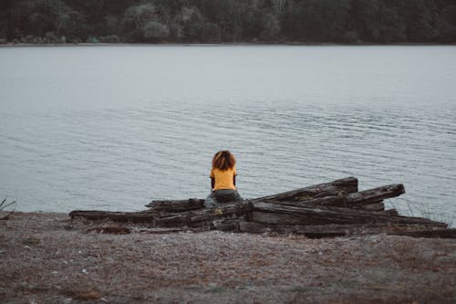 Free Person Wearing Yellow Shirt Sitting Near Lake Stock Photo