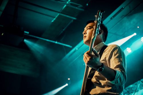 Free Guitarist performing live on stage under dramatic lighting, capturing a musical moment. Stock Photo