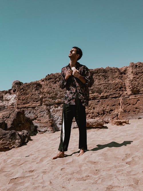 A man standing on a beach with his arms out