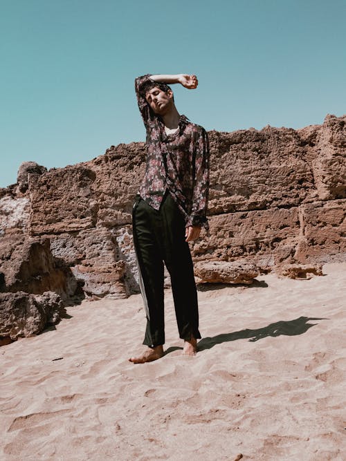 A man in a floral shirt standing on a beach