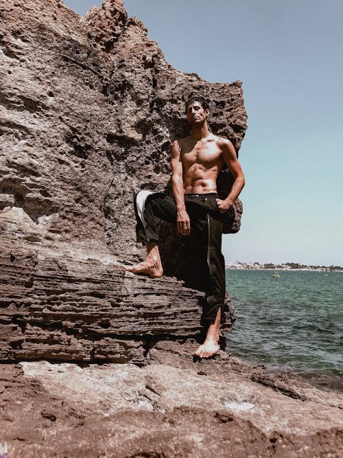 A man standing on a rock near the ocean