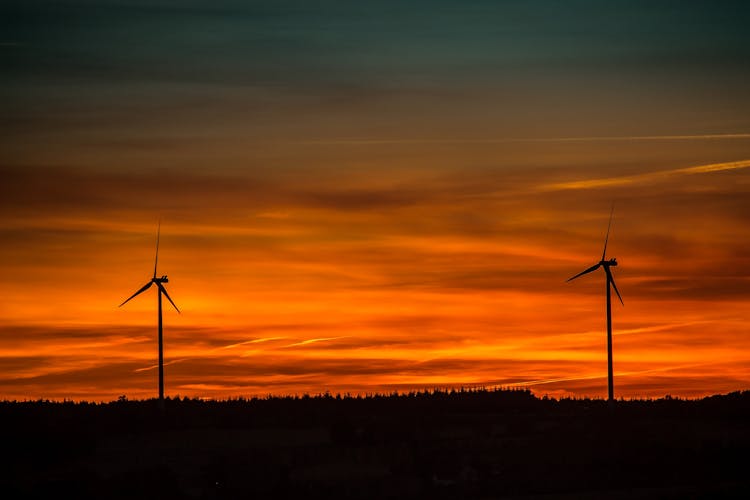 Silhouette Of Windmills Under Orange Sunset