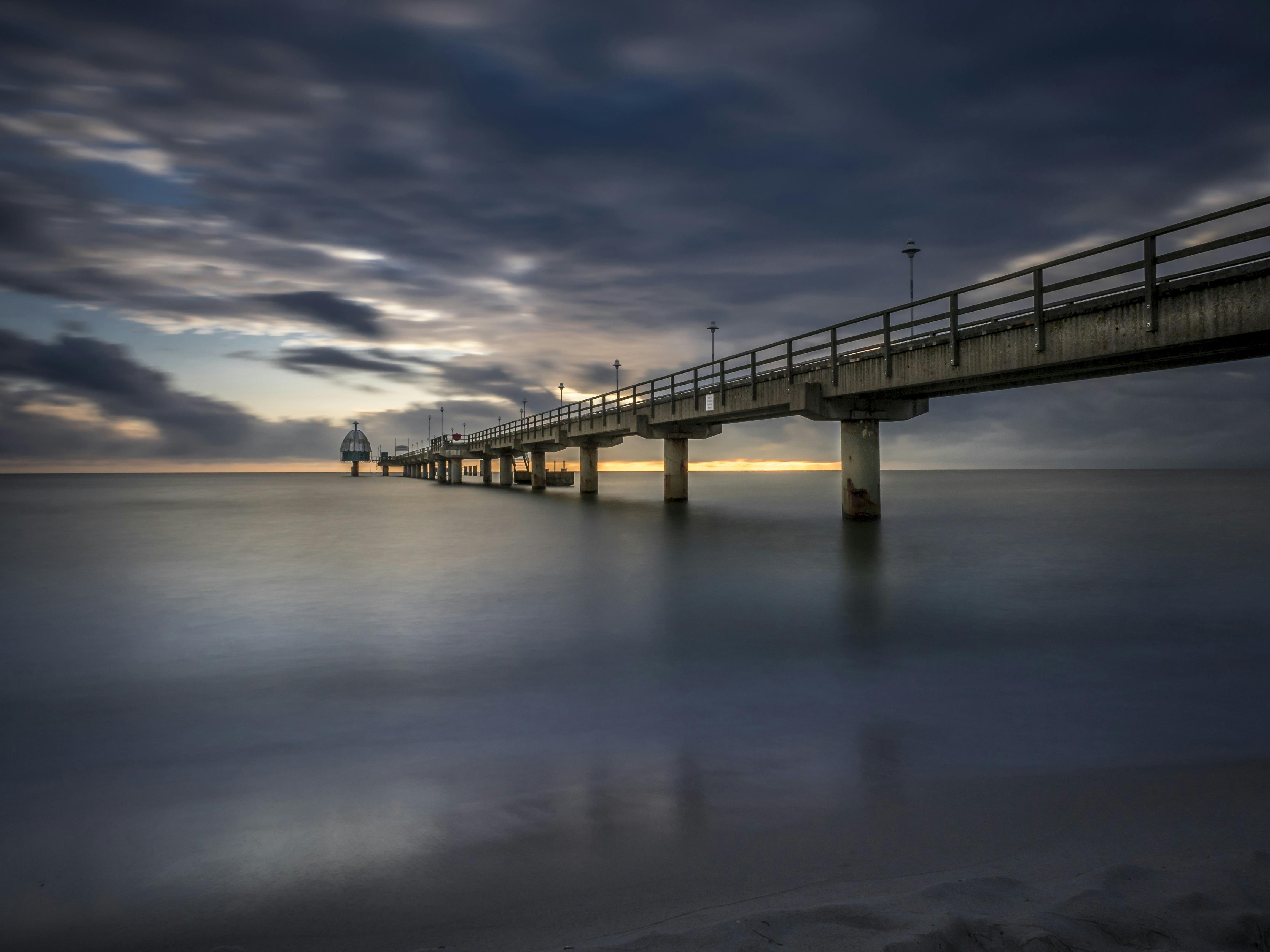 concrete under gray sky bridge long exposure photography