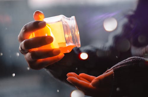 Free Person About to Pour Yellow Liquid on Palm Stock Photo