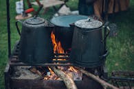 Three Black and Gray Pots on Top of Grill With Fire on Focus Photo