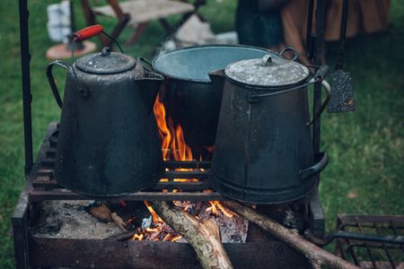 Camp cooking pots over a stove flame