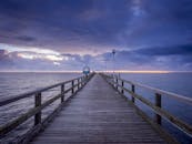 在明媚的日落天空下，一座宁静的码头延伸到波罗的海，捕捉到宁静的海岸美景