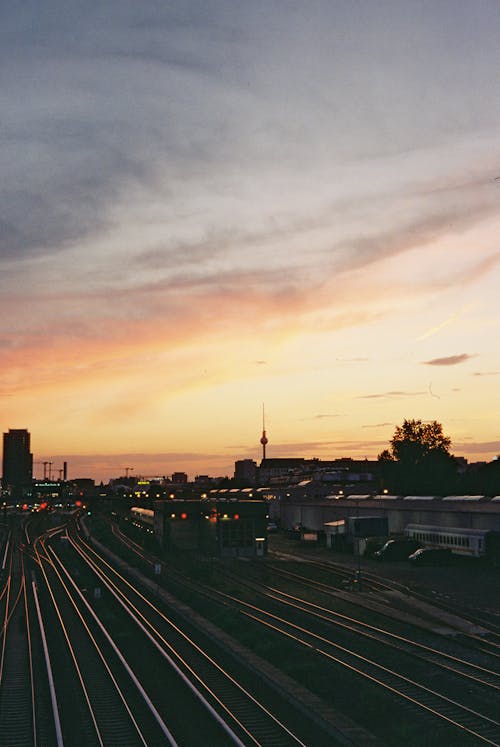 A sunset over a train track with a train in the distance